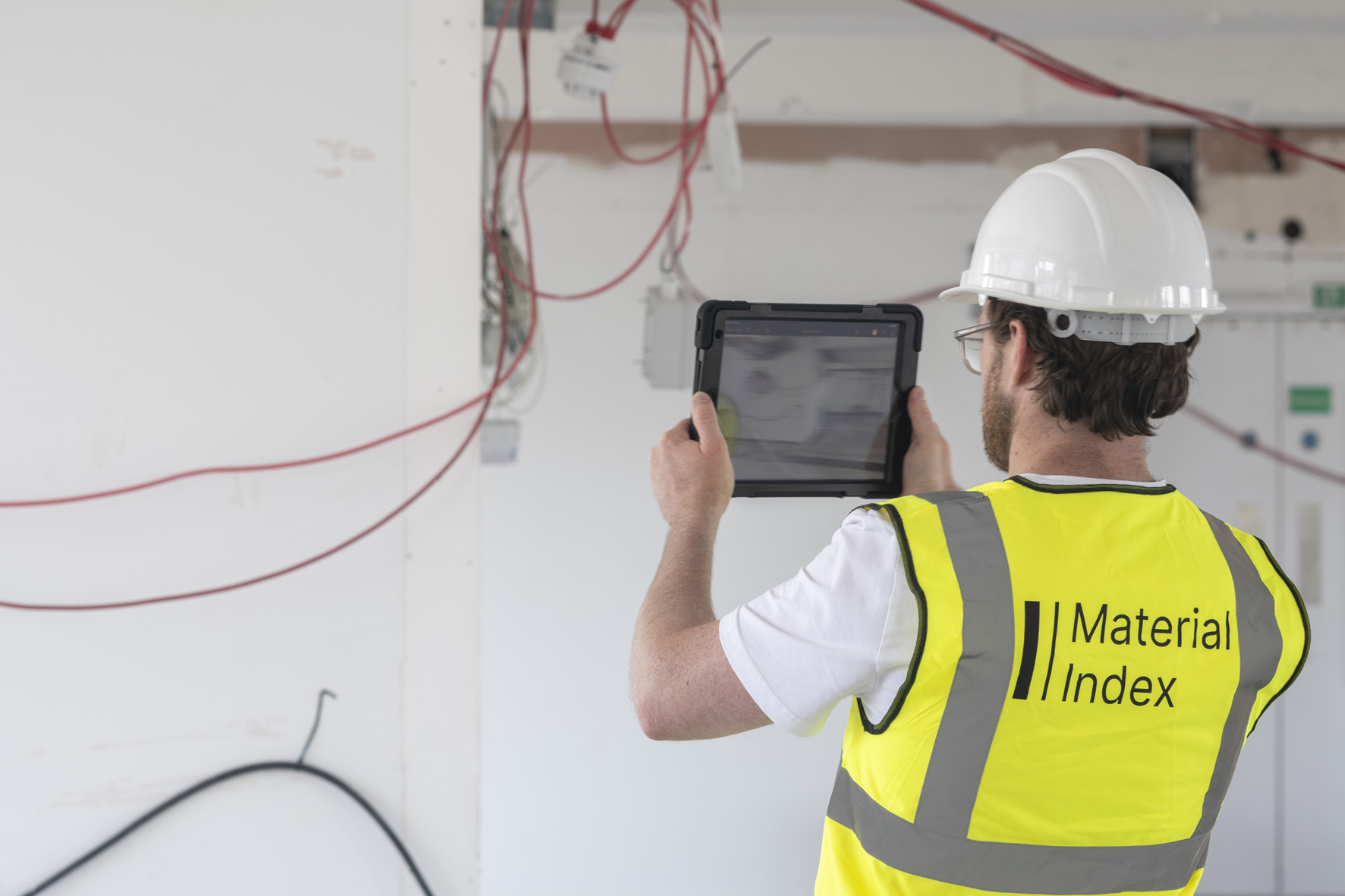 A man wearing hi-vis scanning a building site using Material Index's software.